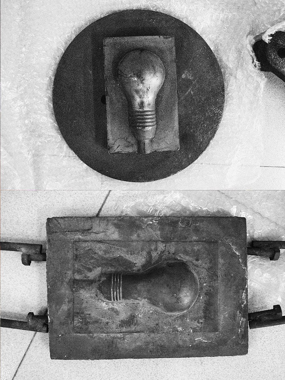 Black-and-white: opened metal moulds with the bulb shape of the Block Lamp at the glassworks.