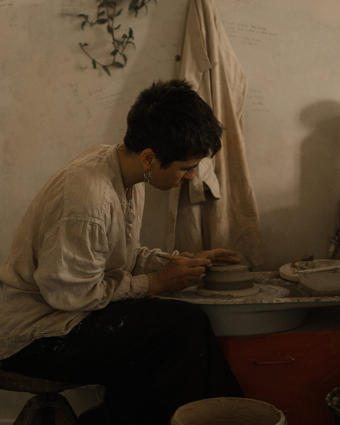 Potter Elise Gettliffe works clay at her wheel in her studio in Alsace.