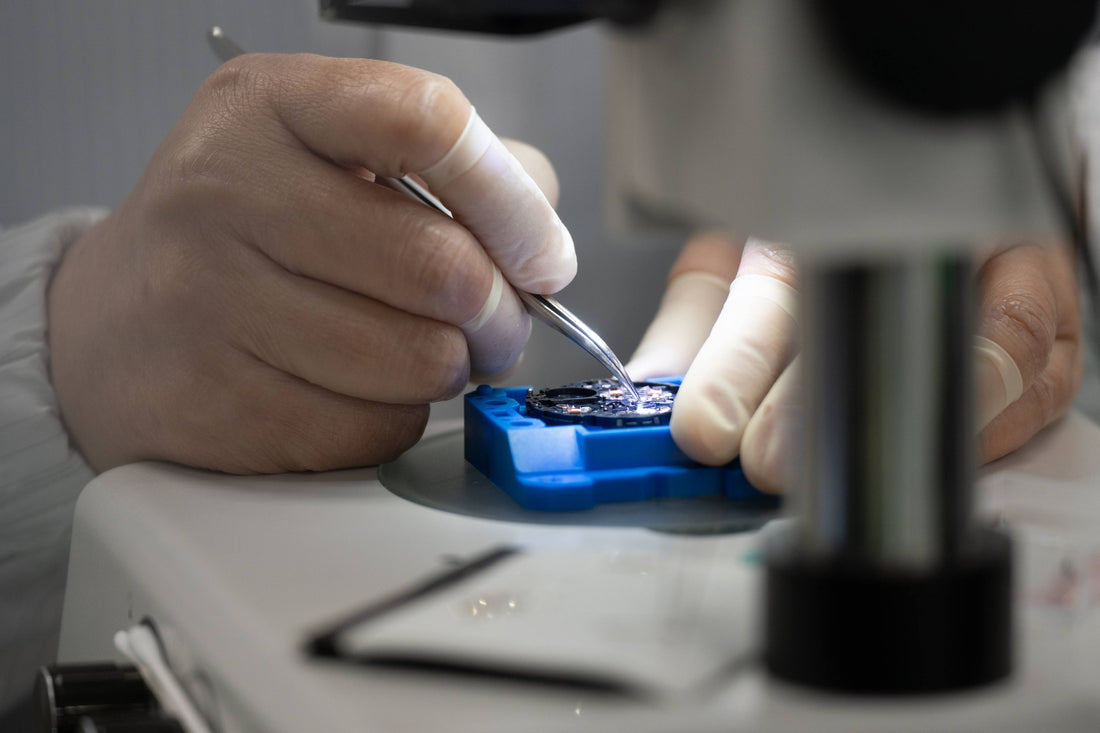 A watchmaker sets parts into a G-SHOCK movement with tweezers under the microscope (Premium Production Line, Yamagata Casio).