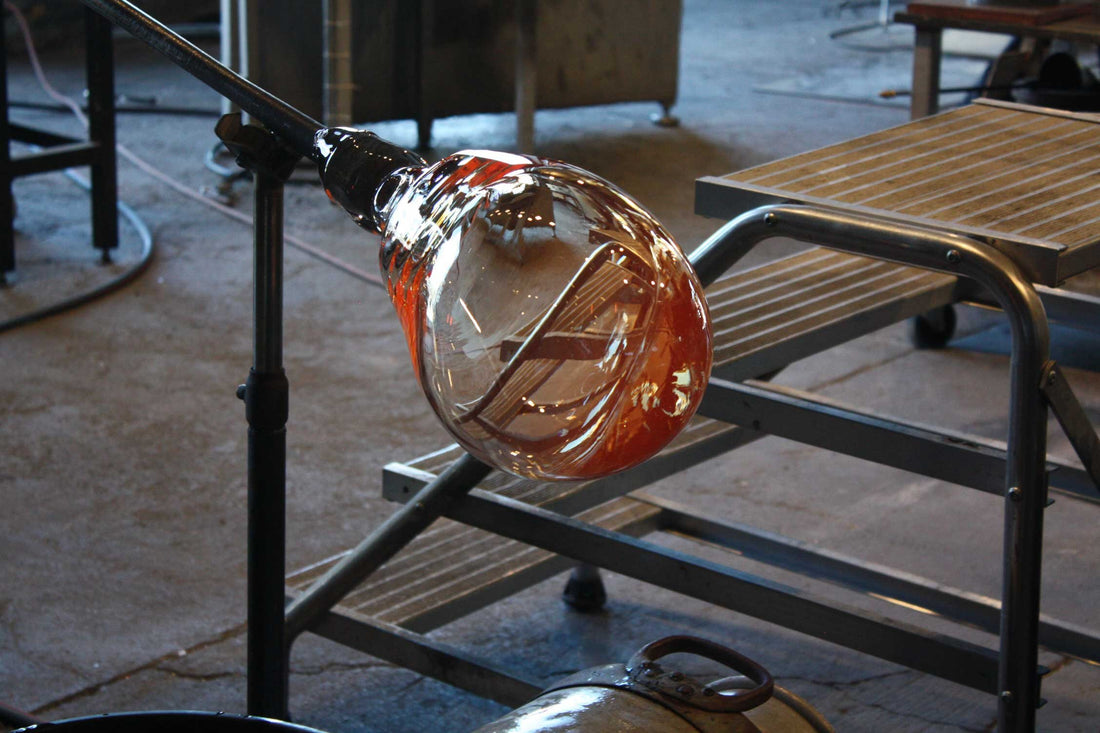 A mouth-blown glass bubble on the blowpipe at the workbench, Holmegaard Glasværk glassworks.
